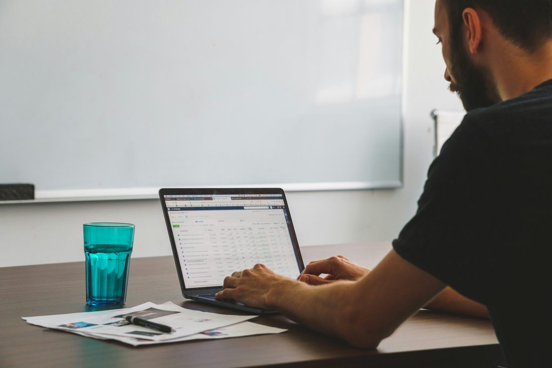 Person working on a laptop with marketing documents
